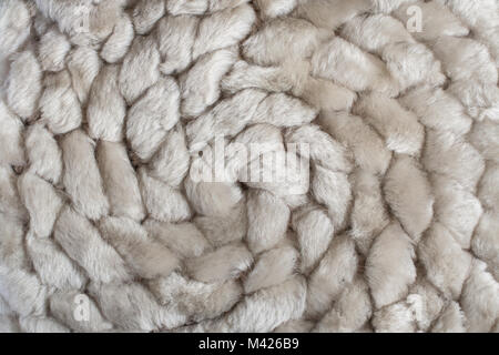 Close-up spiral pattern of knitted natural sheep fur fabric. Stock Photo