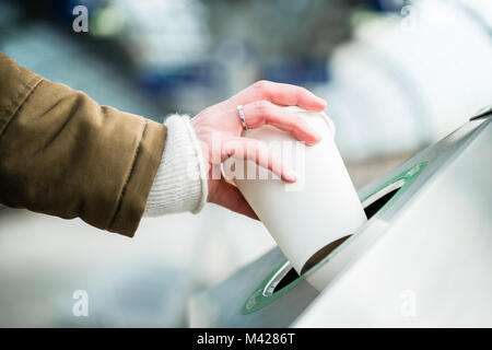 Woman using waste separation container throwing away coffee cup Stock Photo