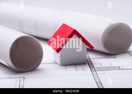 Close-up Of House Model With Rolled Blueprint Stock Photo
