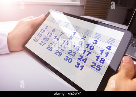 Close-up Of A Man Looking At Calendar On Digital Tablet Stock Photo