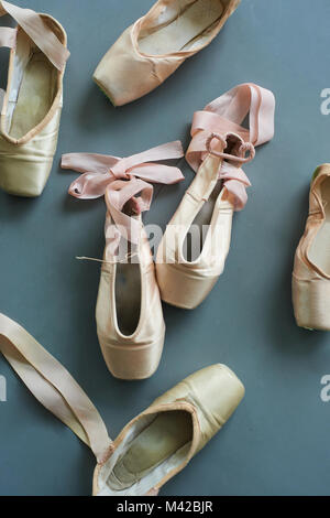 Group of old used pointe shoes. Worn female ballet shoes, top view. Concept of classical ballet. Stock Photo