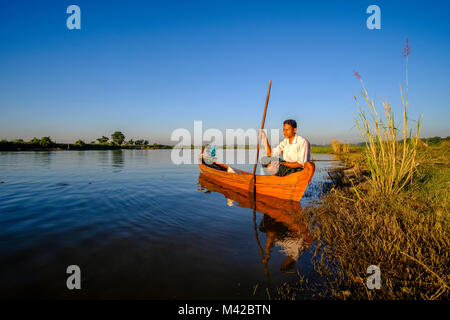 A fisherman, sitting in his boat on Taungthaman Lake Stock Photo