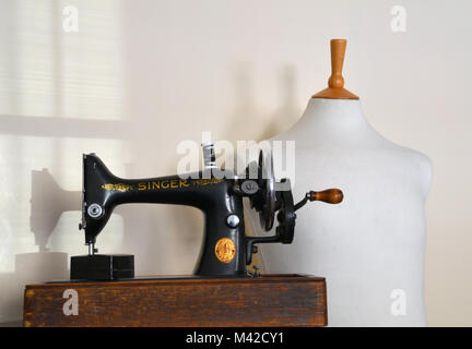 Tailors dummy and hand operating sewing machine. Stock Photo
