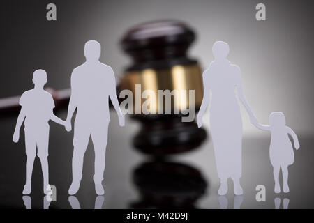 Separation Of Family Figure Cut Out In Front Of Gavel On Grey Background Stock Photo