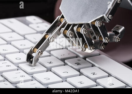 Close-up Of A Robotic Hand Typing On Keyboard Stock Photo