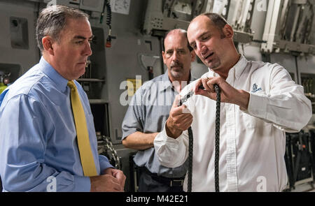 Justin Smoak, Samson Rope application engineering manager, Ferndale, Wash., right, shows Roberto Guerrero, Deputy Assistant Secretary of the Air Force for Operational Energy, Headquarters U.S. Air Force, Washington, D.C., left, and Ed Clark, AFRL aircraft programs support contractor with Concurrent Technologies Corporation, Johnstown, Pa., the weaving of the synthetic winch cable, Sept. 6, 2017, at Dover Air Force Base, Del. The proposed 280-foot synthetic winch cable weighs 14 pounds and is 83 percent lighter than the current 80 pound steel wire cable. (U.S. Air Force Stock Photo