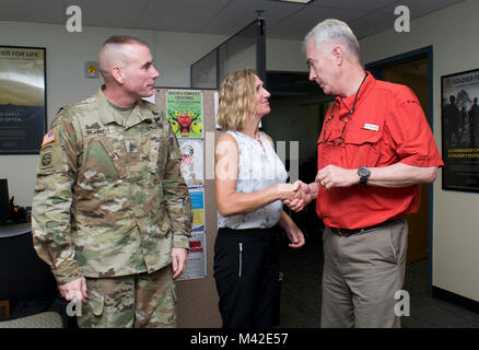 FORT SHAFTER — Ret. Col. Walter M. Herd (right), Army Transition Division director at the Human Resources Command Center of Excellence, presents a challenge coin to Sabrina Newman (center) Transition Services Specialist, Military Personnel Division, U.S. Army Garrison–Hawaii, at Fort Shafter, Feb. 2. Sgt. Maj. Jason Schmidt (left), command sergeant major, Installation Management Command-Pacific, attended a meeting with Herd at the Transition Assistance Program Center. (U.S. Army Stock Photo