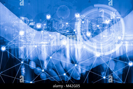 Double exposure of businessman hand check mobile and network connection technology with city scape at night. Stock Photo