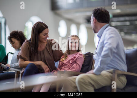 Mother and Child talking with Doctor in waiting room Stock Photo