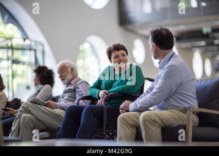 Disabled woman talking with Doctor in waiting room Stock Photo