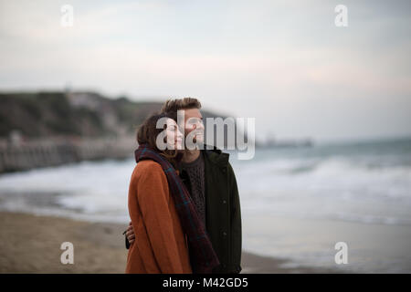 Young adult couple walking on beach Stock Photo