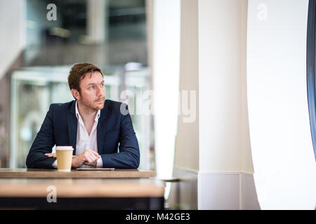 Businessman in a café looking out of the window Stock Photo