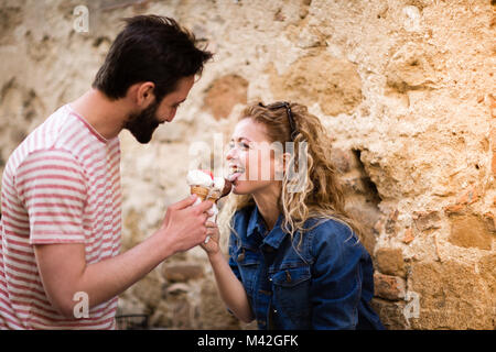 Young female eating gelato with boyfriend Stock Photo