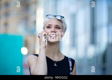 Young adult commuting and using smartphone Stock Photo