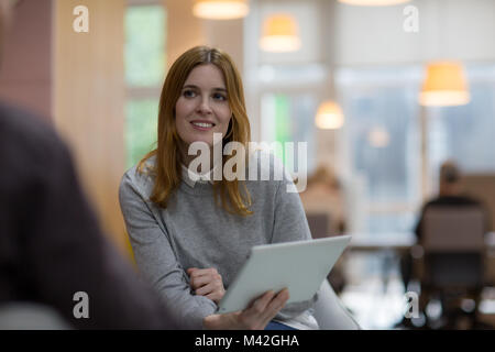 Businesswoman in a meeting holding a digital tablet Stock Photo