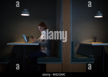 Businesswoman working late at night in office alone Stock Photo