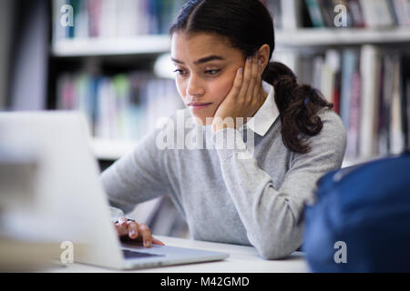 Student working on laptop in library Stock Photo