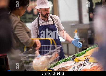 Customer asking fishmonger for advice Stock Photo