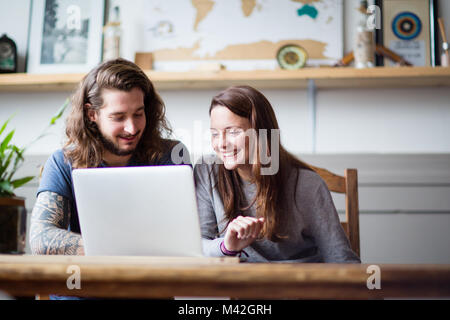 Young adult couple using a laptop together Stock Photo