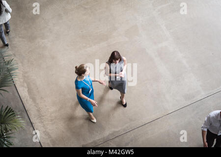 Overhead shot of a two businesswomen walking through an office Stock Photo