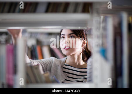 Student looking for a book in library Stock Photo