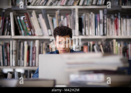 Student working on laptop in library Stock Photo