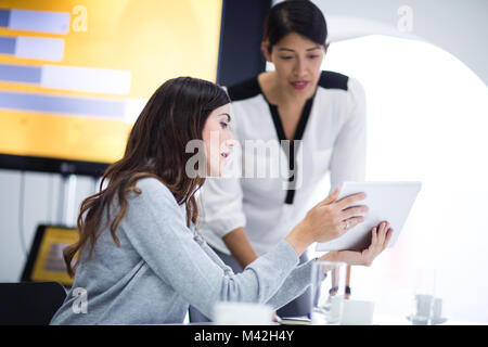 Female business executives discussing report in a meeting Stock Photo