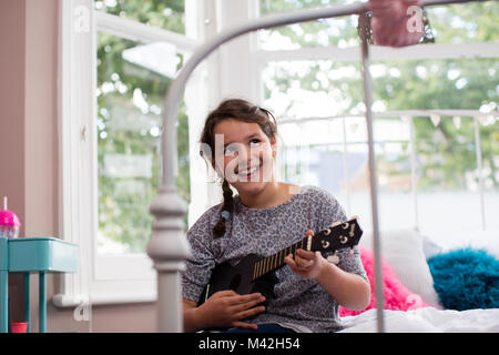 Girl playing a ukulele Stock Photo