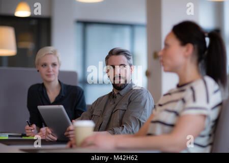 Businessman listening to female coworker in a meeting Stock Photo