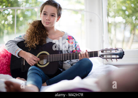 Teenager playing acoustic guitar Stock Photo