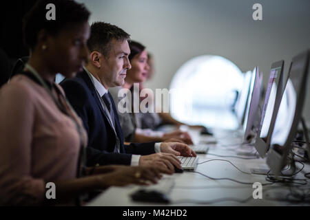Businessman using computer in crowded office Stock Photo