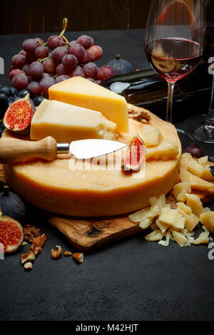 Whole round Head of parmesan or parmigiano hard cheese and wine Stock Photo