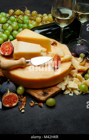 Whole round Head of parmesan or parmigiano hard cheese and wine Stock Photo