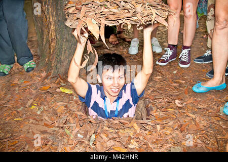 CU CHI, VIETNAM - NOV 17: A guide demonstrating how a Vietcong hide into the Tunnel on Nov 17 2013. Cu Chi, Vietnam.Cu Chi tunnels were the Viet Cong' Stock Photo