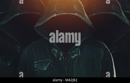 Group of hooded computer hackers with obscured faces lined up in formation as army soldiers. Programmers, internet experts and cybersecurity Stock Photo