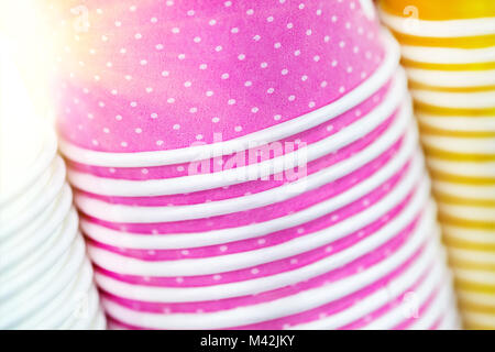 Multicolored paper cups. Bright food and drink background. Stack of colorful containers. Close up pile of glasses.  Abstract background texture Stock Photo