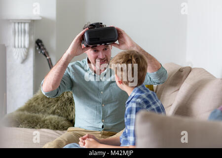 Father and Son using a virtual reality glasses at home Stock Photo