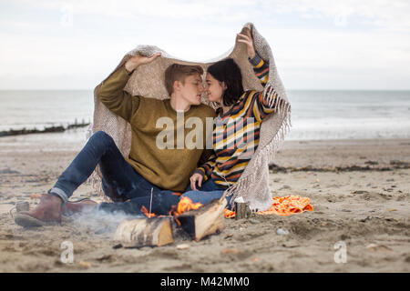 Young couple kissing under a blanket Stock Photo