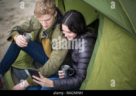 Young couple using a smartphone on a camping trip Stock Photo
