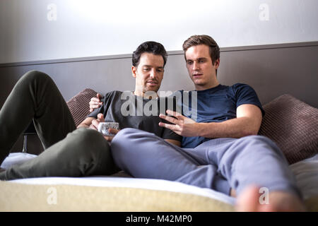 Young male couple looking at smarphone together Stock Photo