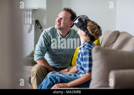 Boy using a VR headset game at home with Father Stock Photo