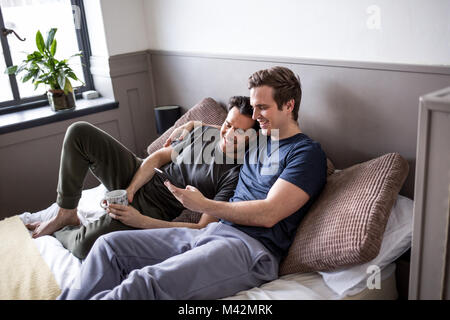 Young male couple looking at smarphone together Stock Photo