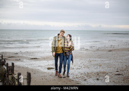 Young couple walking on a beach in winter Stock Photo