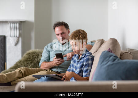 Father and Son individually using technology Stock Photo