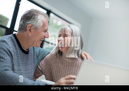 Happy senior couple using a laptop together Stock Photo