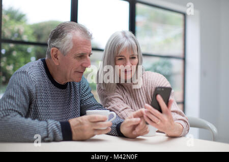 Senior couple using a smartphone together Stock Photo
