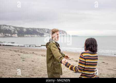 Couple holding hands on a winter beach break Stock Photo