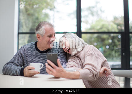 Senior couple using a smartphone together Stock Photo
