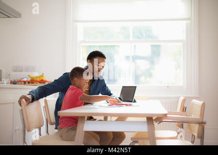 Father helping Son with school work Stock Photo