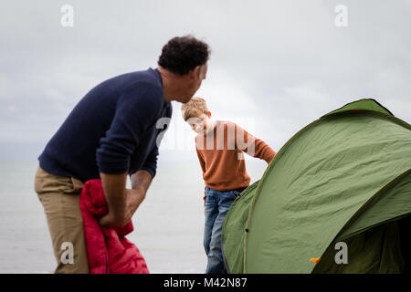 Father and Son putting up a tent together Stock Photo